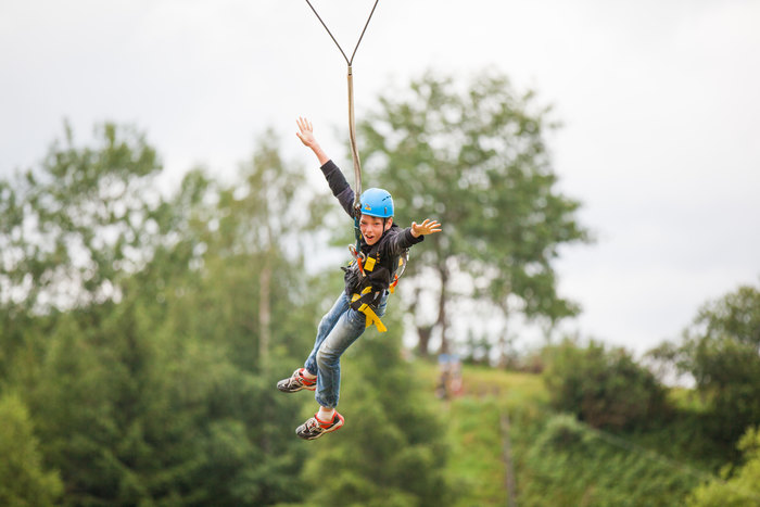 Ein Junge seilt sich im internationalen Sommercamps ab