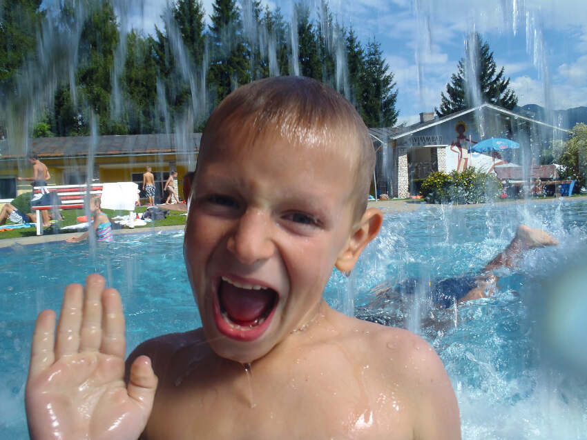 Junge beim Plantschen im Freibad im Sommercamp Österreich