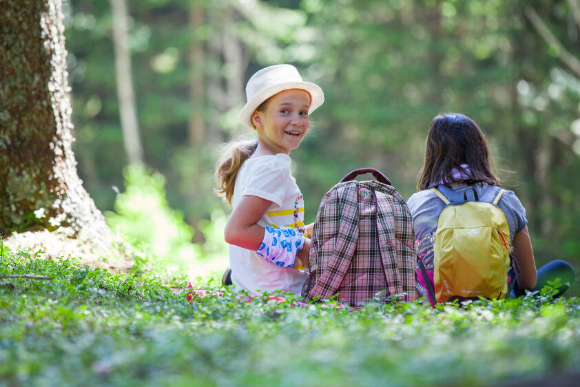 Mädchen bei Wanderpause im Wald im Kidscamp in Österreich