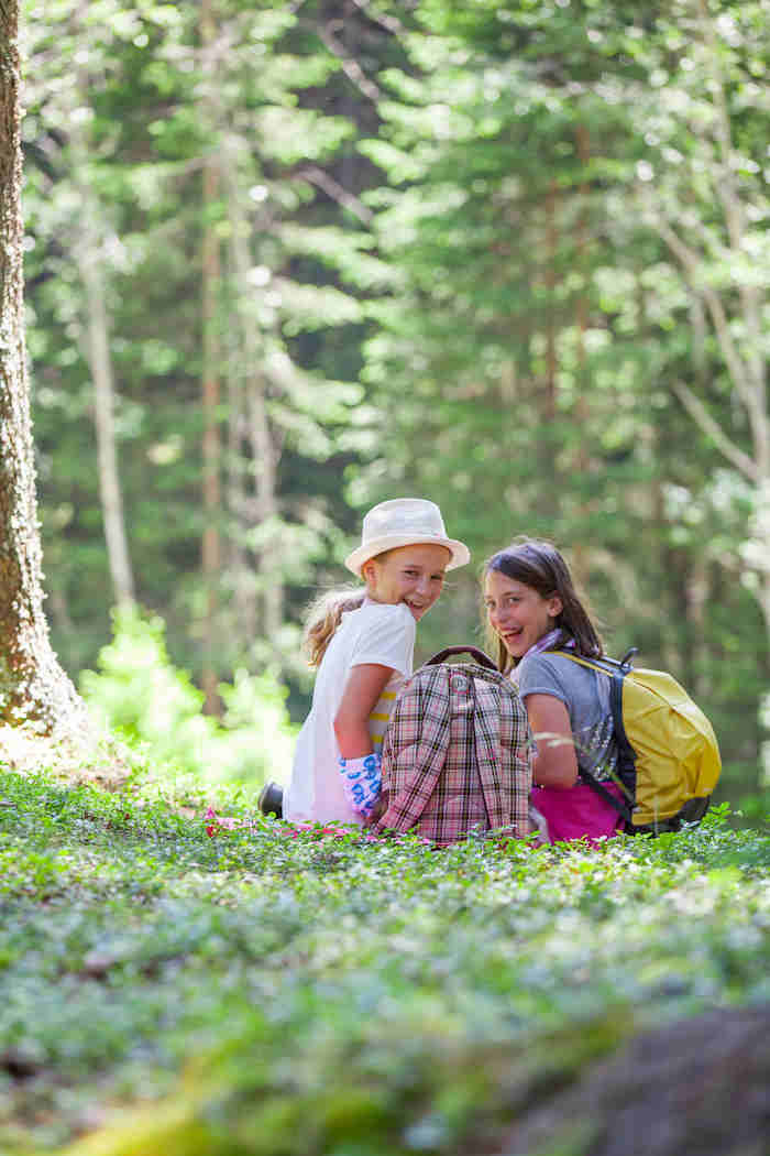 Zwei Mädchen sitzen im Wald im Kidscamp Österreich