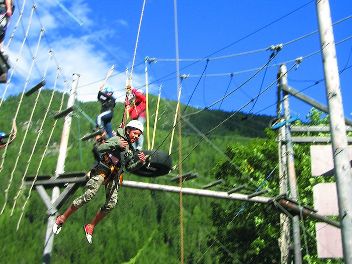 Participants of the Summer Camps England climb in the high ropes course. 