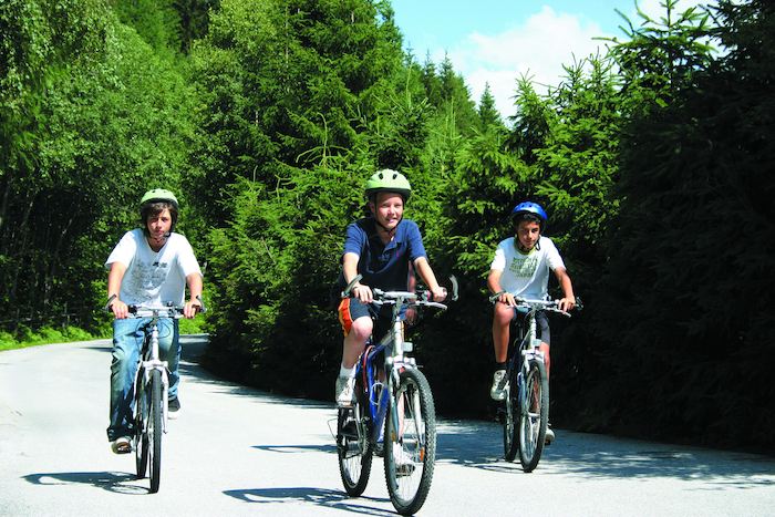 Drei Jungen fahren Fahrrad auf der Jugendreise Österreich