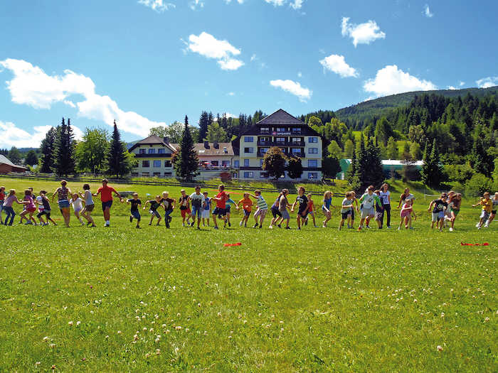 Kindergruppe rennt über Wiese im Abenteuercamp Österreich