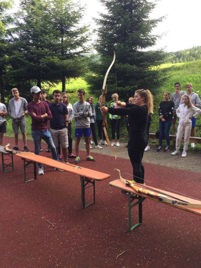 Eine Teilnehmerin des Feriensprachkurses für Schüler schießt mit Pfeil und Bogen