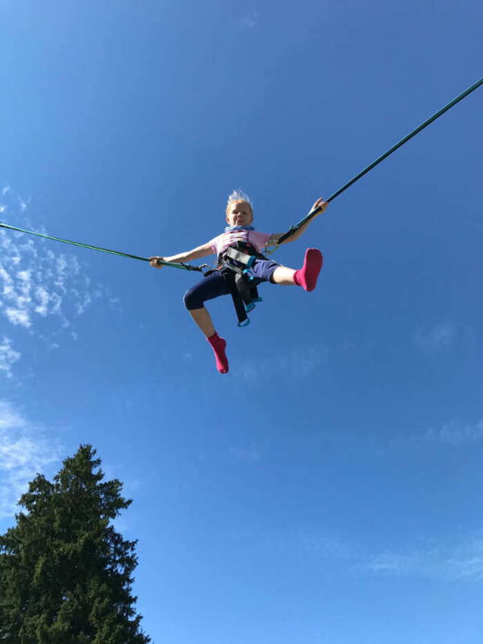 Ein Mädchen des Feriensprachkurses für Schüler springt auf einem Trampolin