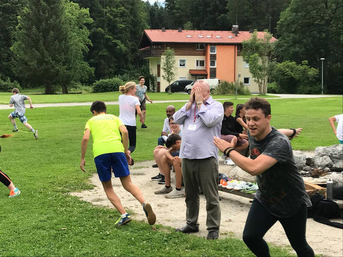 Teilnehmer eines Ferien-Sprachkurses spielen verstecken