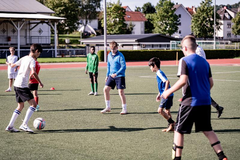 Eine Gruppe Kinder und Jugendliche trainieren zusammen Fußball im Ferienprogramm Heidelberg