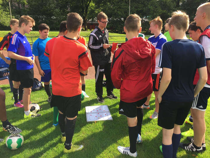 Jungs bei Taktikbesprechung im Fußballcamp