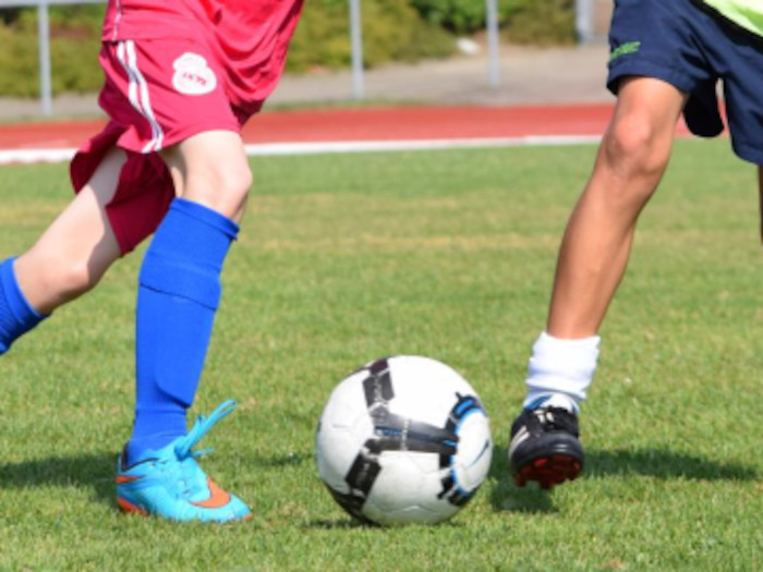 Die Kinder im Fußballcamp liefern sich bei einem Spiel auch mal einen Zweikampf.