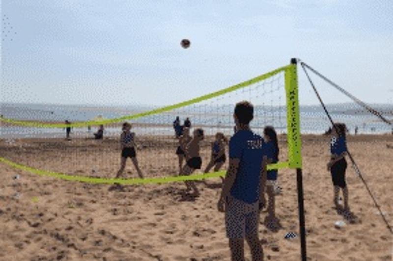Kinder eines Sportcamps Kinder Sommerferien spielen Beachvolleybal