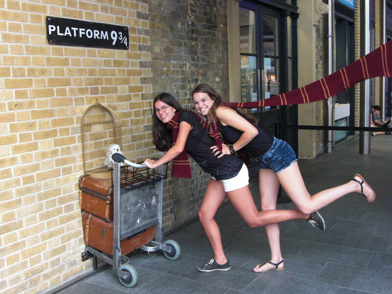 Mädchen posieren auf der Platform 9 3/4, lachen