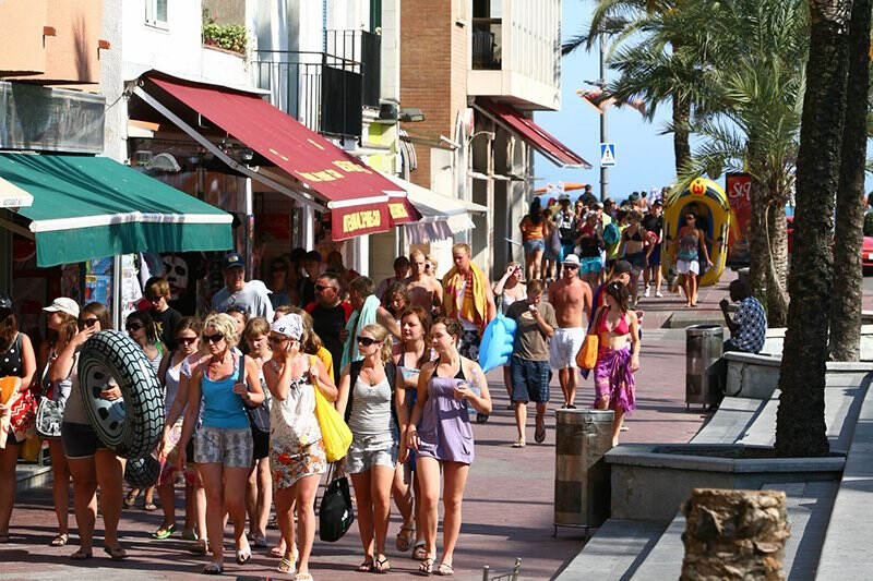 Touristen bummeln an einem Platz während der Jugendreise nach Spanien entlang