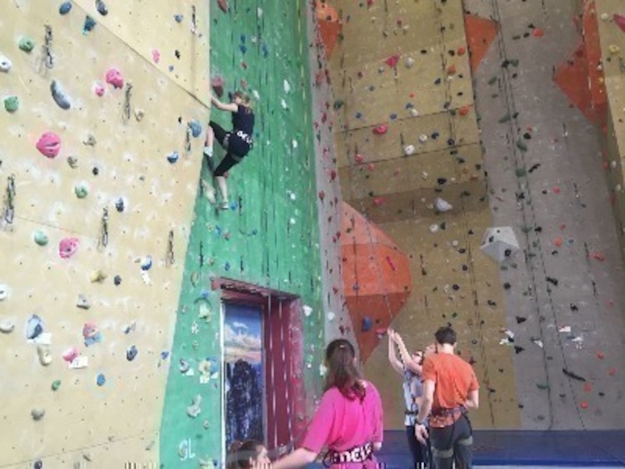 Mädchen klettert an der Boulderwand im Ferienlager in Thüringen