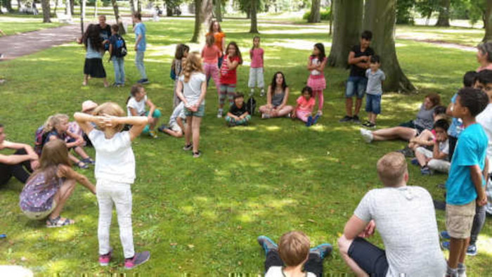 Kinder im Sitzkreis auf der Wiese im Ferienlager in Thüringen