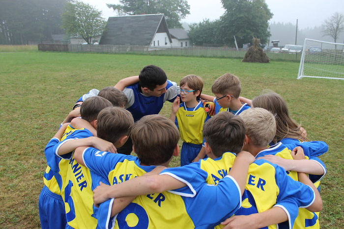 Kinder in Trikots bilden einen Kreis im Herbstcamp Johanngeorgenstadt