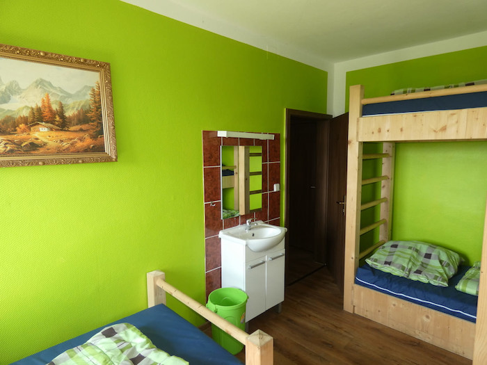 Grünes Zimmer mit Waschbecken im Herbstcamp Johanngeorgenstadt