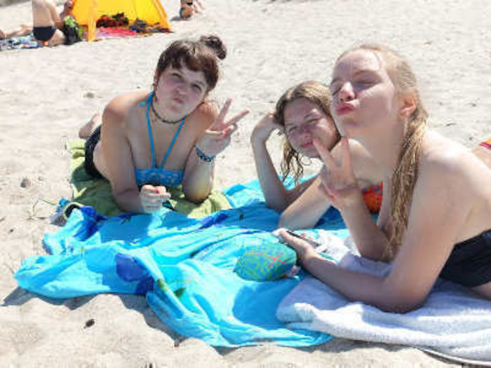 Mädchen zeigen Peace am Strand im Ferienlager in Mecklenburg-Vorpommern