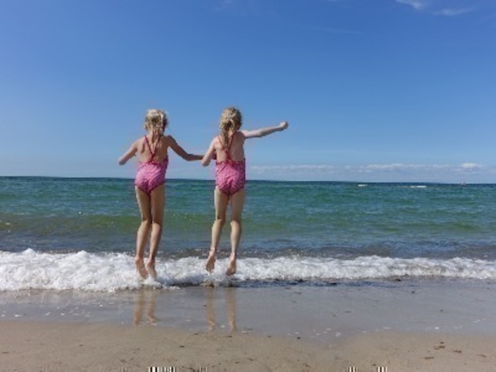 Zwei Mädchen auf Kinderreise stehen am Strand