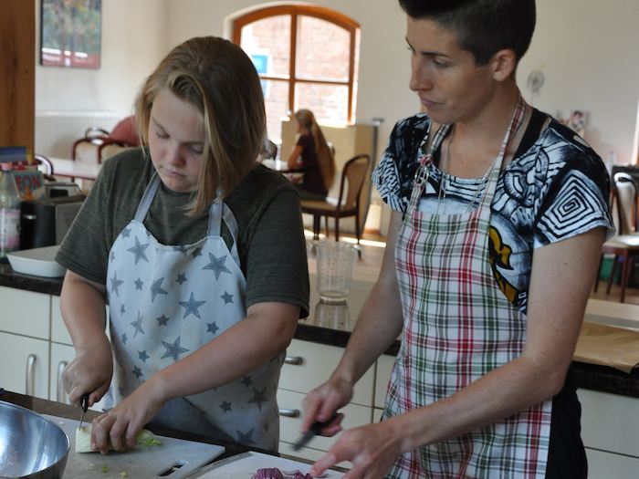 Mädchen und Betreuerin schnippeln im Kreativcamp