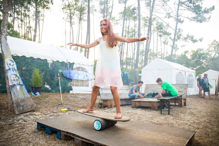 Frau balanciert auf Indoboard im Surfcamp