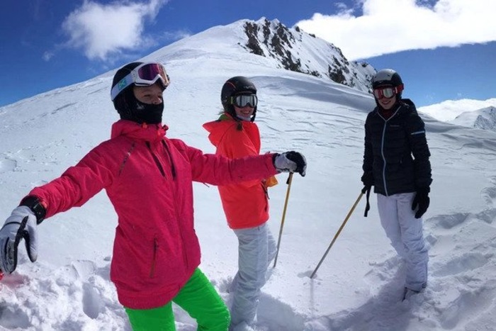Jugendliche stehen in Skimontur auf einem schneebedeckten Berghang im Salzburger Alpenland