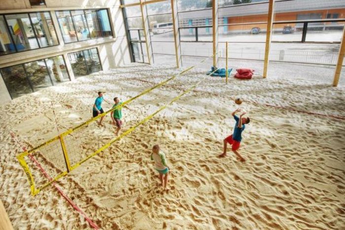 Jugendliche auf dem Beachvolleyballfeld der Sporthalle des Jugendhotels Club Kitzsteinhorn in Zell am See