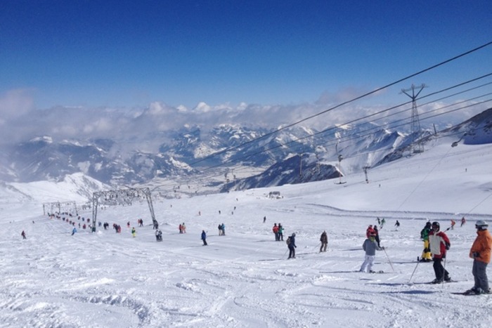 Skifahrer lassen sich im Salzburger Alpenland von einem Schlepplift zur Pistenabfahrt hinaufziehen