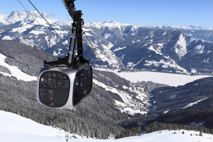 Seilbahngondel in Zell am See mit dem schneebedeckten Salzburger Alpenland im Hintergrund