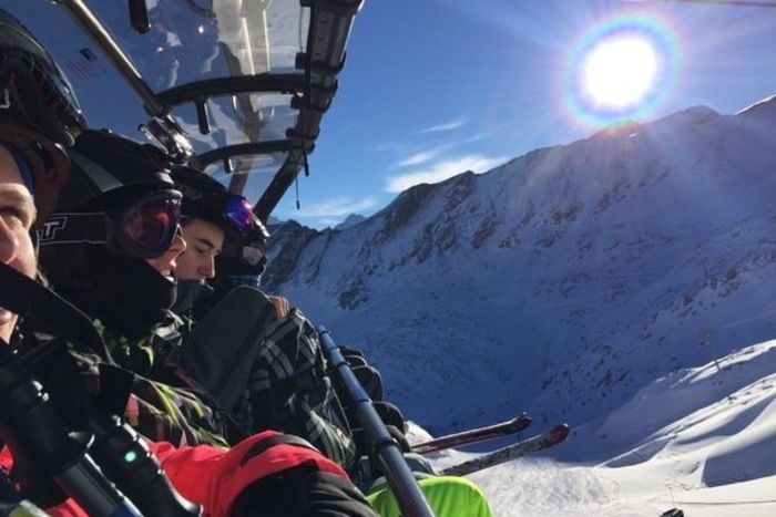 Jugendliche sitzen in einer Gondel eines Skilifts im Salzburger Alpenland
