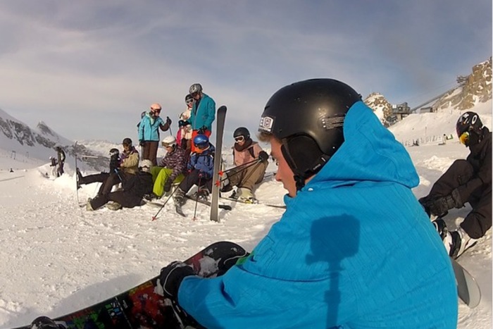 Jugendliche machen sich mit Skiern und Snowboads auf einem Berg im Salzburger Alpenland abfahrbereit