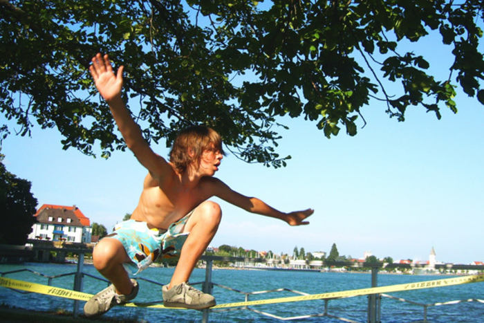 Junge auf einer Slackline am Ufer des sommerlichen Zeller Sees