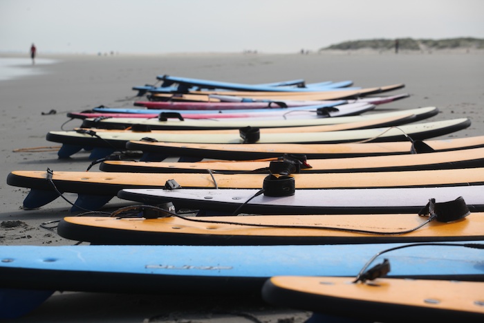 Surfboards liggen op het strand tijdens zomerkamp Spanje.