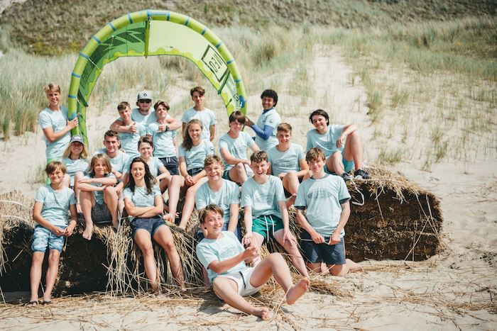 Eine Gruppe Jugendliche einer Ferienfreizeit Hannover sitzt am Strand