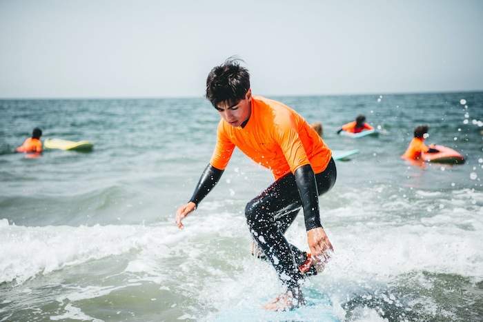 Junge surft auf Surfbrett in Surfcamps Ostsee