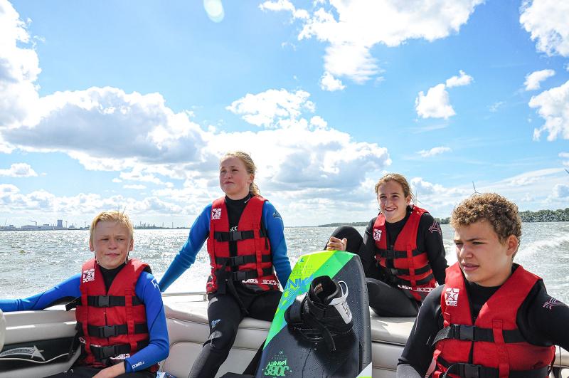 Kinder eines internationalen Feriencamps tragen Westen