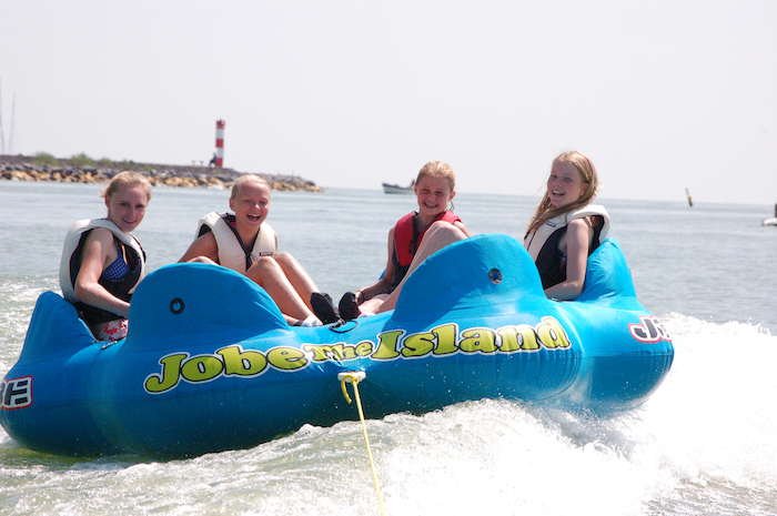 Tienermeisjes poseren lachend in bananenboot. 