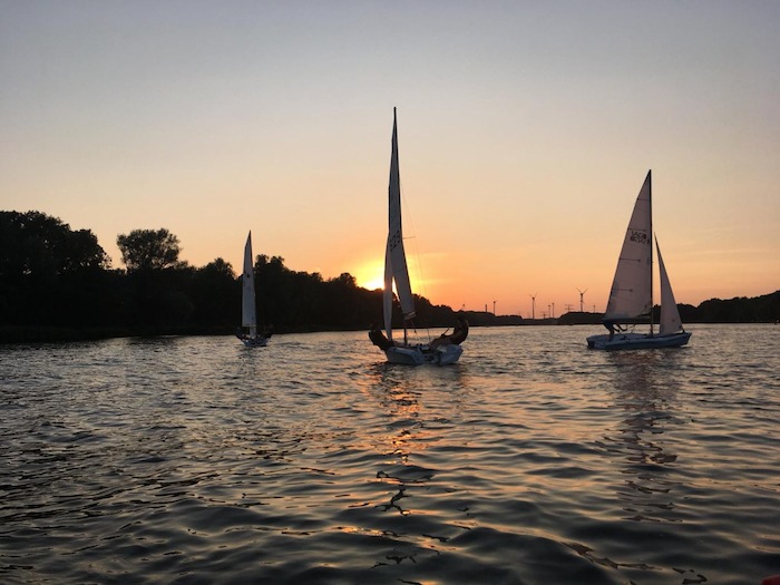 Zeilboten in Rotterdam varen bij de ondergaande zon.