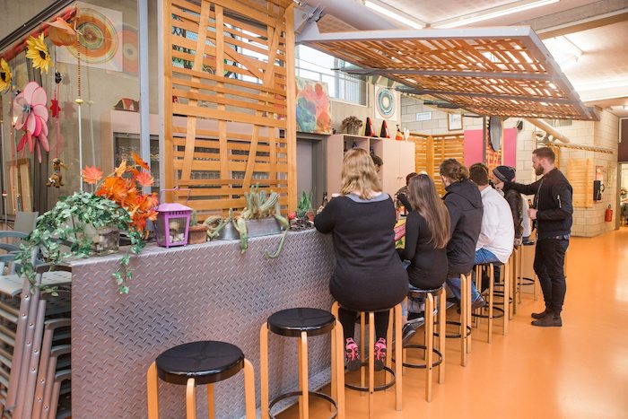 Jongeren op kamp Mechelen zitten aan hippe bar.