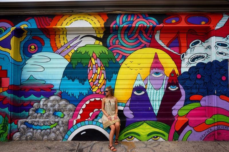 Op zomerkamp Brugge poseert meisje tegen kleurrijke graffitimuur