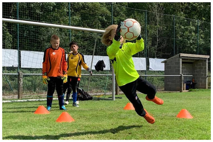 Jongen reikt springend naar bal op kamp meivakantie.