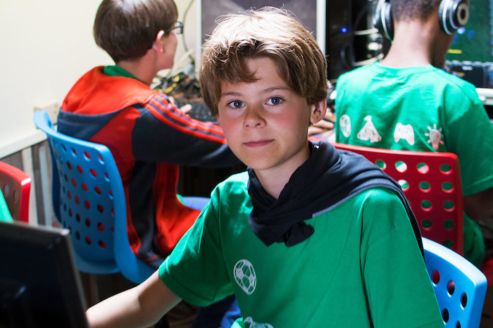 Jongetje poseert voor de camera op computerkamp.