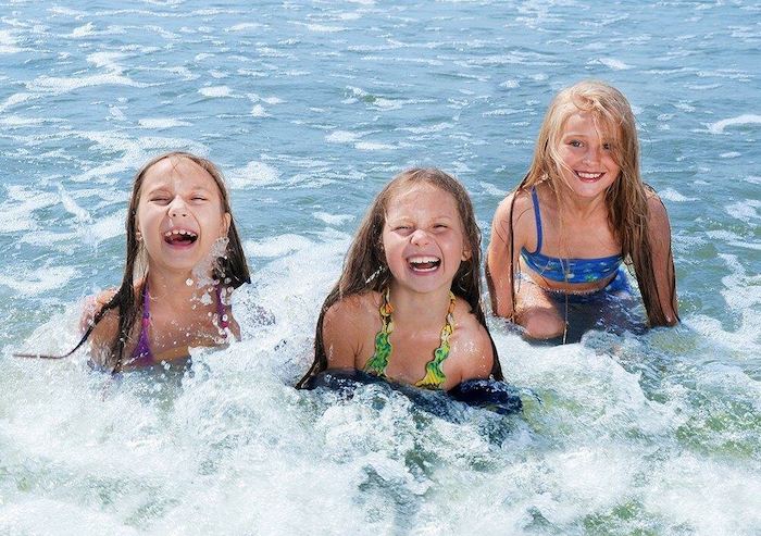 Mädchen planschen lachend im Wasser im Ferienlager an der Ostsee