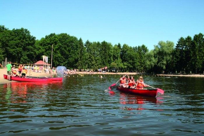 Kinder fahren am Strand mit dem Boot im Feriencamp in den Niederlanden