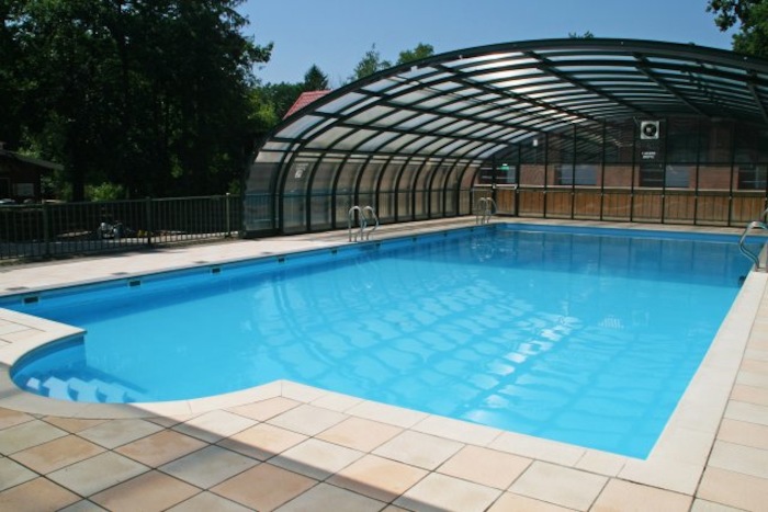 Halbüberdachtes Schwimmbad bei Sonne im Feriencamp in den Niederlanden