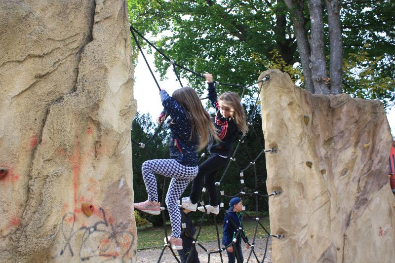 Kinder klettern an einer Kletterwand während dem Ferienangebot Sachsen