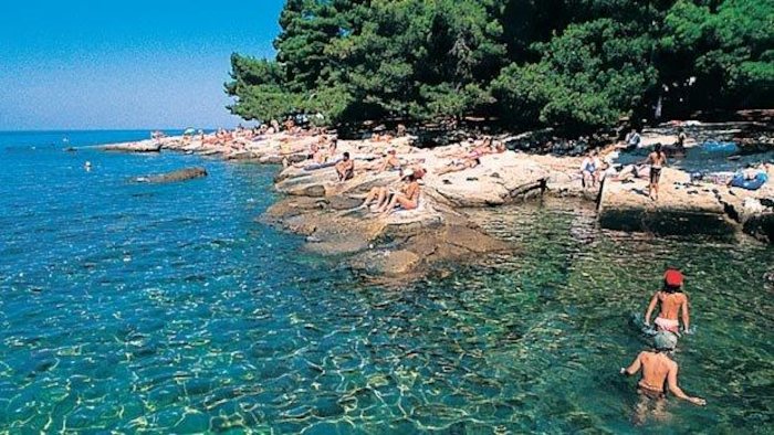 Viele Menschen an felsiger, flacher Küste auf der Jugendreise nach Kroatien