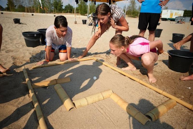 Kinder spielen ein Strandspiel im Teenscamp