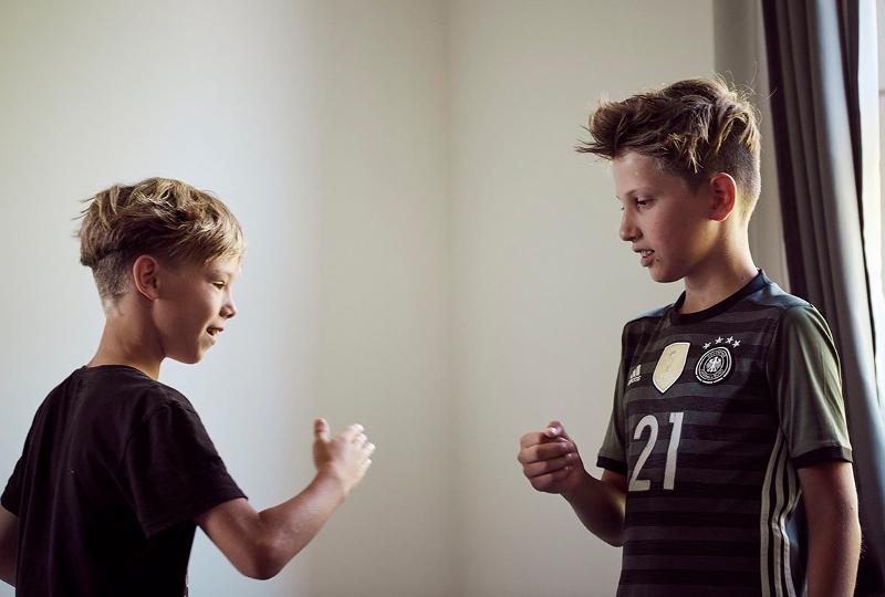 Jungs der Ferienbetreuung Marburg spielen Schere Stein Papier zusammen