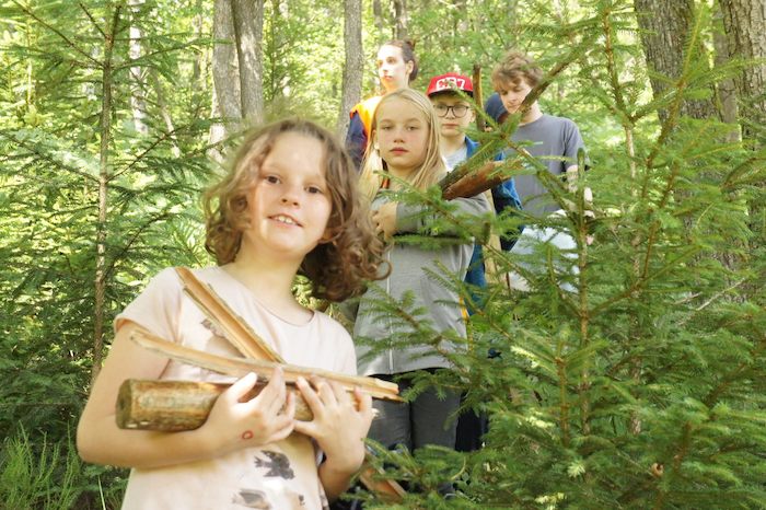 Kinderen sprokkelen hout tijdens avonturenkamp.