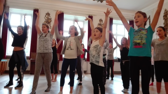 Mehrere Kinder tanzen gerade in ihrem Feriencamp wie bei einem Musical